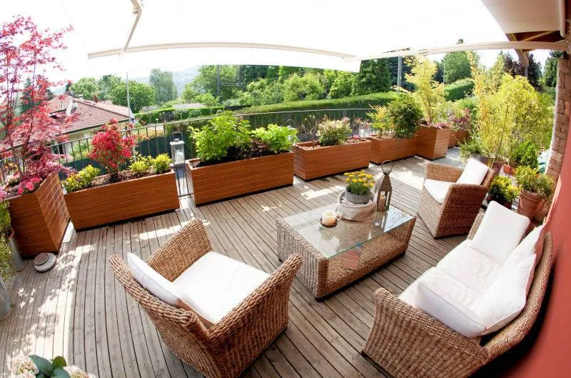 Un esempio di terrazzo arredato con mobili di vimini e piante