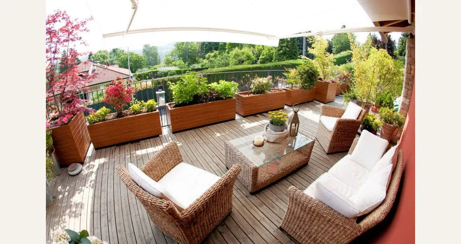 Un esempio di terrazzo arredato con mobili di vimini e piante